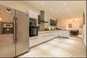 una cucina con elettrodomestici in acciaio inossidabile e pavimento in cucina di Superbe grande maison de ville! a Solomiac