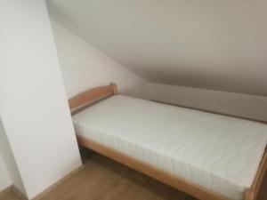 ein kleines Schlafzimmer mit einem Bett in der Ecke in der Unterkunft apartma Burjuca in Ajdovščina