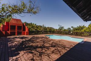 a swimming pool in a yard with a tree at Private eco-estate with sweeping ocean views No Load shedding totally off-grid property in Southbroom