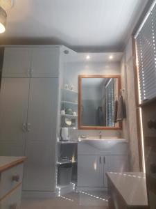 uma casa de banho com um lavatório e um espelho em Tranquillity em Southbourne