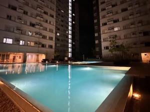 a large swimming pool with a fountain in front of buildings at Avida Tower 2 Mountain View Condominium in Davao City