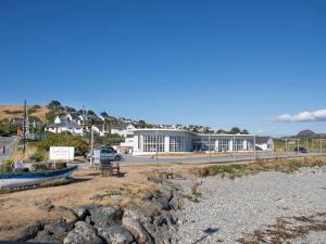 a building on the side of a road next to a beach at Ty Copr Perlog in Criccieth