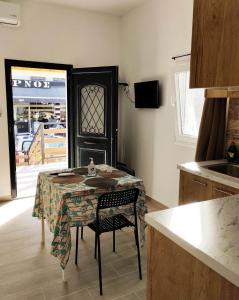 a kitchen with a table and chairs and a stove at Nikolas' house in Nea Iraklia