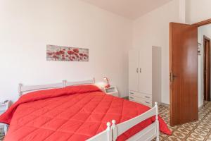 ガリポリにあるAppartamento Belvedere Vista Mareのベッドルーム1室(赤いベッド1台、クローゼット付)