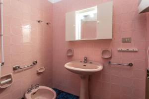 ガリポリにあるAppartamento Belvedere Vista Mareのピンクのバスルーム(シンク、トイレ付)