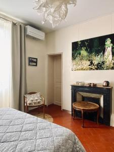ein Schlafzimmer mit einem Bett, einem Kamin und einem Kronleuchter in der Unterkunft La maison Gerval in Bédoin