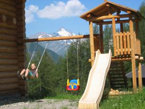 a woman sitting on a swing at a playground at Tomperkasa in Apriach