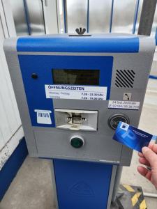 una persona está insertando una tarjeta de crédito en un parquímetro en Kempten - Lebendig und voller Geschichte en Kempten