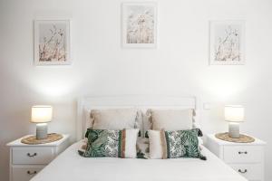 1 dormitorio con 1 cama blanca y 2 lámparas en Nazaré Modern Flat, en Nazaré