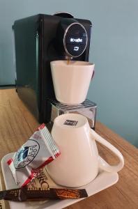 a cup of coffee and a coffee maker on a table at AAB Studio Central in Piatra Neamţ +8 photos