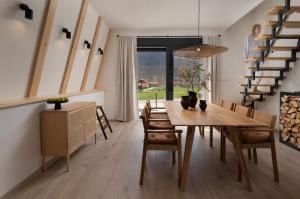 a dining room with a wooden table and chairs at Oak House in Brušane