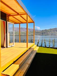 een houten terras met uitzicht op het water bij Lago Maggiore Bay in Baveno