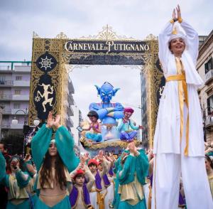 un grupo de personas delante de una carroza en un desfile en L'Angolo di Gaudì, casa Milà, en Putignano