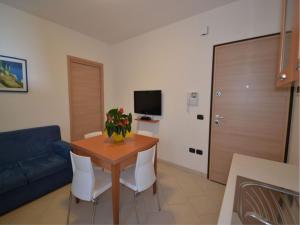 uma sala de estar com uma mesa e um sofá azul em Modern flat with private garden in Rosolina Mare em Rosolina Mare