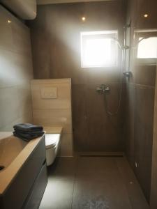 a bathroom with a shower and a toilet and a sink at Tesy in Sveti Filip i Jakov