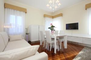 una sala de estar blanca con mesa y sillas en City Apartments San Marco, en Venecia