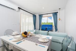 comedor con mesa y sofá azul en Newly Designed 3BR Fusion House in Yamu Garden B1 en Ban Bang La