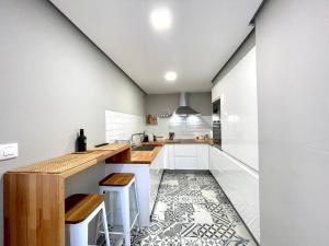 a kitchen with white cabinets and a tile floor at Apartamento céntrico y cerca de la playa in Ribeira