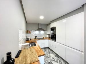 a kitchen with white cabinets and a counter top at Apartamento céntrico y cerca de la playa in Ribeira