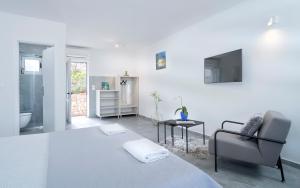 a white bedroom with a bed and a chair at Villa Serenity in Hvar