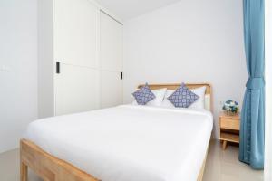 een slaapkamer met een wit bed en blauwe gordijnen bij Newly Designed 3BR Fusion House in Yamu Garden B1 in Ban Bang La