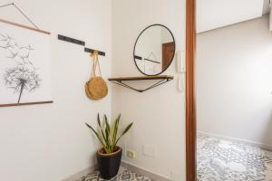 a hallway with a mirror and a potted plant at Apartamento céntrico y cerca de la playa in Ribeira