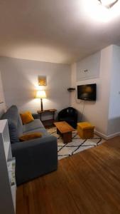 sala de estar con sofá y TV en Maison 6-9 pers pour vacances et cure thermale, en Le Mont-Dore
