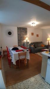 ein Wohnzimmer mit einem Tisch und einem Sofa in der Unterkunft Maison 6-9 pers pour vacances et cure thermale in Le Mont-Dore