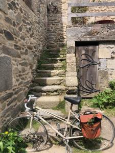 a bike parked next to a stone building with a door at Les Jeux du Vent -Saint Jacut de la mer in Saint-Jacut-de-la-Mer