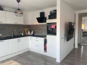 eine Küche mit weißen Schränken und schwarzen Arbeitsplatten in der Unterkunft Executive Maisonette Penthouse Loft, Rooftop Pool, Central Hannover and Direct Messe Connection in Hannover