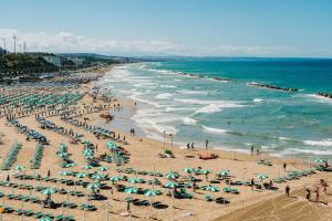 a beach with many umbrellas and crowds of people at Casa di Nonna Linda in Portocannone