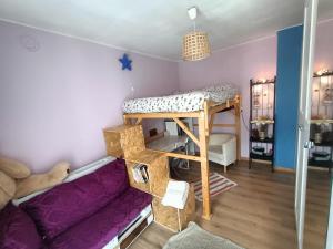 Zimmer mit einem Etagenbett und einem lila Sofa in der Unterkunft Appartamento vista panoramica Bussoleno in Bussoleno