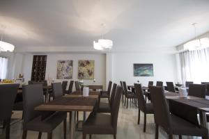 a dining room with tables and chairs and paintings at Hotel Diamante in Negrar