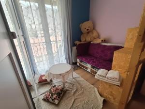 a small room with a teddy bear sitting on a bed at Appartamento vista panoramica Bussoleno in Bussoleno