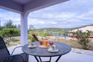 a table with two cups of orange juice on a patio at Villa Serenity in Hvar