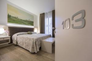 a white bedroom with a bed and a window at Hotel Diamante in Negrar