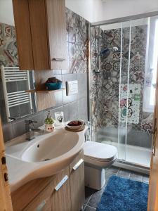 ein Bad mit einem Waschbecken, einem WC und einer Dusche in der Unterkunft Appartamento vista panoramica Bussoleno in Bussoleno