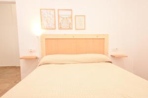 1 cama en un dormitorio con 2 cuadros en la pared en BITA Home en Barbate