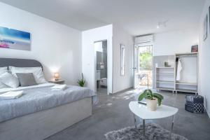 a white bedroom with a bed and a table at Villa Serenity in Hvar +40 photos