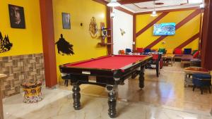 a pool table in a room with yellow walls at Hogwartz Hostel in Kasol
