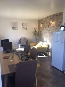 a living room with a table and a refrigerator at Joli appartement Les Archers in Montpeyroux