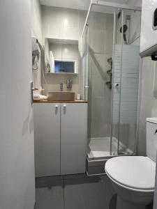 a bathroom with a toilet and a shower and a sink at T2 Paris 5 ' Tour Eiffel 15' Parking in Le Kremlin-Bicêtre