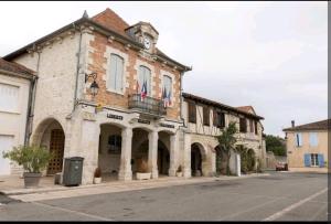 un vecchio edificio con una torre dell'orologio su una strada di Superbe grande maison de ville! a Solomiac