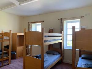 a room with three bunk beds and a window at Jersey Accommodation and Activity Centre in Gorey