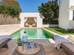 a pool with a table with a bottle of water at Casa Lloc Tranquil in Cala Figuera