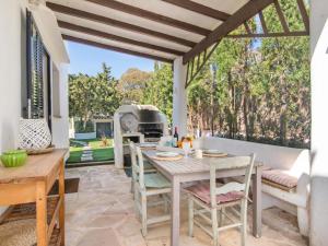 a patio with a table and chairs and a grill at Casa Lloc Tranquil in Cala Figuera