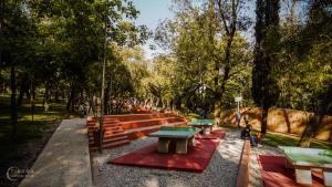 een rij picknicktafels en banken in een park bij Laku Apartment - At The Heart of Tirana in Tirana +5 foto's