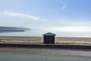 une petite cabane assise sur le côté d'une plage dans l'établissement Hotel Østersø, à Åbenrå