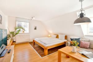 uma sala de estar com uma cama e um sofá em Ferienappartements Stralsund em Stralsund