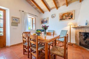 een eetkamer met een tafel en stoelen en een open haard bij Can Jaumins in Sóller